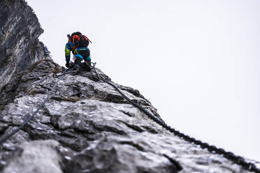 Man climbing on rocky mountain via ferratta - MCVF00958