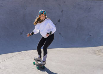 Junge Frau übt Skateboardfahren auf einem Pumptrack - STSF03153