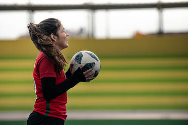 Frau hält einen Fußball in der Hand - CAVF95901