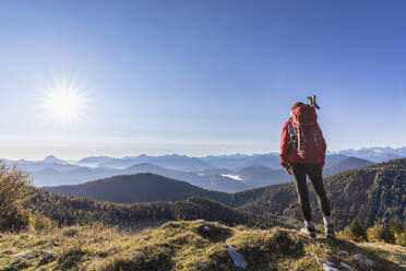 Wanderin bewundert die Bayerischen Voralpen bei nebligem Sonnenaufgang - FOF13029