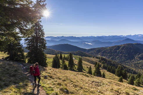 Wanderin bewundert die Bayerischen Voralpen bei nebligem Sonnenaufgang - FOF13037