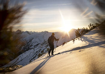 Man with ski pole walking on snowcapped mountain - MALF00397