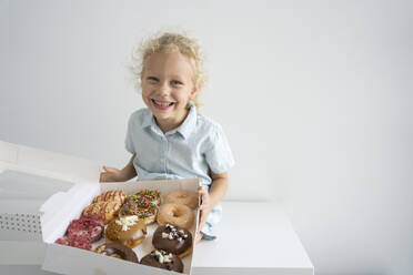 Lächelndes Mädchen hält Schachtel mit Donuts - SVKF00042
