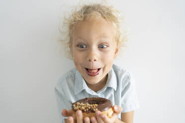 Happy blond girl enjoying doughnut - SVKF00051