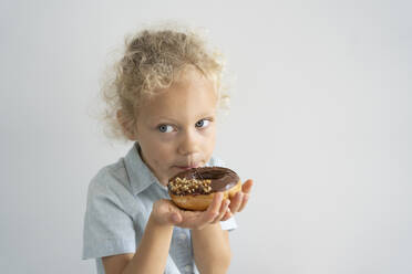 Blond girl eating doughnuts at home - SVKF00056