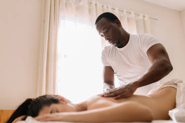 Afroamerikanischer professioneller Therapeut bei einer Schultermassage - CAVF95938