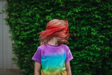 Young girl shaking head with tousled hair - CAVF95957