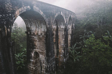 Luftaufnahme der berühmten Neun-Bogen-Eisenbahnbrücke, die durch eine grüne Dschungellandschaft im Morgennebel führt, Ella, Sri Lanka. - AAEF14248