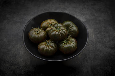 Studio shot of bowl of dark cabomar tomatoes - LVF09216