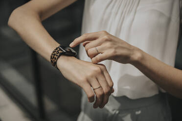 Young woman touching smart watch on sunny day - MFF08982