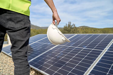 Ingenieur mit Schutzhelm vor Solarzellen auf dem Dach - VEGF05534