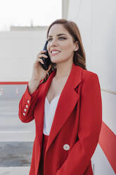 Smiling businesswoman talking on mobile phone - JRVF02891