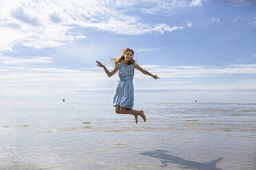 Girl jumping at beach on sunny day - OJF00493