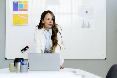 Geschäftsfrau mit Laptop am Schreibtisch im Büro - GIOF14947