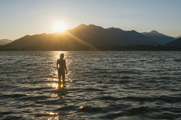 Female swimming in bikini during sunset at lake wenatchee - CAVF95984