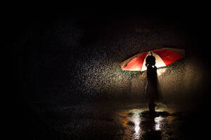 Silhouette eines Mädchens unter einem Regenschirm im Regen - CAVF95994