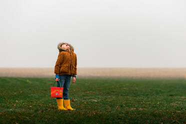 A boy tasting rain outside on Easter Day in the front yard - CAVF96051