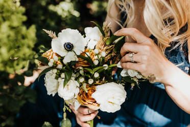 Close up of blonde female holds bouquet of fresh flowers - CAVF96174