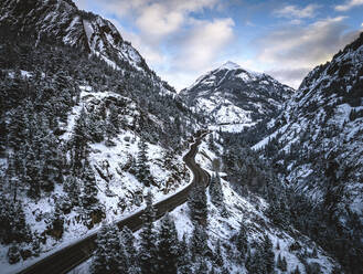 Verschneite Straße schlängelt sich durch die Berge, Red Mountain Pass, Colorado - CAVF96180