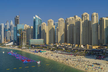 Luftaufnahme von Menschen, die sich im Sommer am Strand entlang der Küste entspannen, Dubai, Vereinigte Arabische Emirate. - AAEF14300