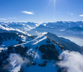 Luftaufnahme eines mit Schnee bedeckten Berggipfels im Winter, Luzern, Schweiz. - AAEF14344
