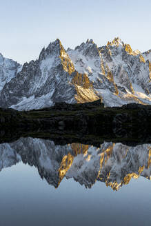 Felsgipfel der Aiguilles de Chamonix spiegeln sich im Lacs des Cheserys bei Sonnenuntergang, Mont-Blanc-Massiv, Haute Savoie, Französische Alpen, Frankreich, Europa - RHPLF21755