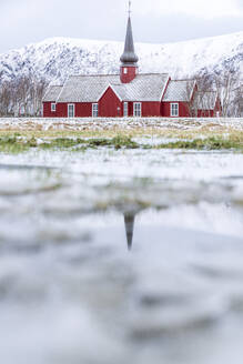 Die Kirche von Flakstad spiegelt sich im Winter in einem Teich, Bezirk Nordland, Lofoten, Norwegen, Skandinavien, Europa - RHPLF21873