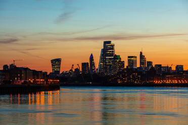 Die Skyline der Stadt London bei Sonnenuntergang spiegelt sich in der Themse, London, England, Vereinigtes Königreich, Europa - RHPLF21898