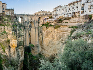 Erstaunliche Kulisse der historischen Steinbogenbrücke Puente Nuevo in der Schlucht El Tajo in der Stadt Ronda mit den typischen weißen Häusern an einem sonnigen Tag - ADSF34382