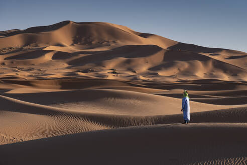 Ein Berber in traditioneller Kleidung in den Sanddünen von Erg Chebbi, Wüste Sahara, Marokko, Nordafrika, Afrika - RHPLF21974