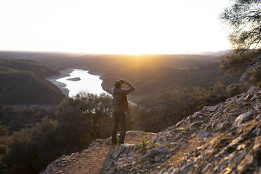 Spain, Province of Caceres, Man bird-watching in Monfrague National Park at sunset - JCCMF05863