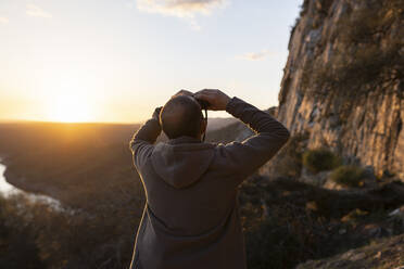 Mann beobachtet Vögel im Monfrague-Nationalpark bei Sonnenuntergang - JCCMF05872