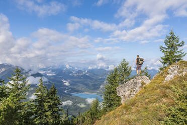 Männlicher Wanderer bewundert die Aussicht auf den Sylvenstein-Stausee und die umliegenden Berge - FOF13056