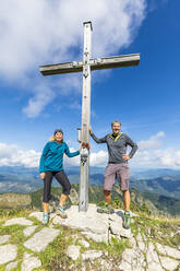 Zwei Wanderer posieren am Gipfelkreuz des Demeljochs - FOF13065