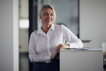 Lächelnde Geschäftsfrau mit Tablet-PC vor einem Schrank im Büro - RBF08813