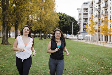 Fröhliche Schwestern joggen im öffentlichen Park - DCRF01079