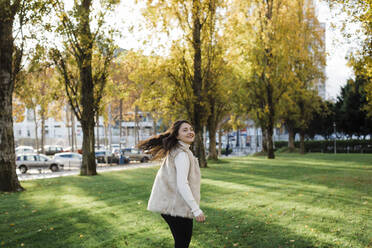 Happy woman enjoying at public park on sunny day - DCRF01092