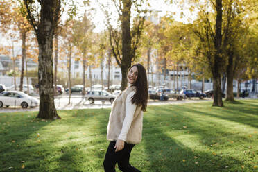 Happy young woman enjoying at public park on sunny day - DCRF01093