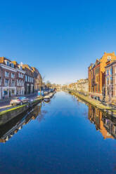 Netherlands, South Holland, Leiden, Clear blue sky reflecting in city canal - THAF03066