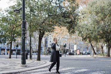 Woman crossing street in city - DCRF01103