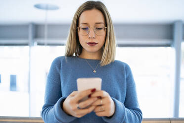 Young woman using mobile phone - FBAF01966