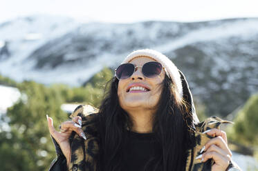 Lächelnde Frau mit Sonnenbrille genießt den sonnigen Tag - PGF01050