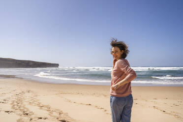Happy woman running towards sea at beach on sunny day - DIGF17794