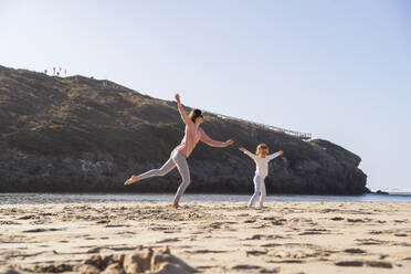 Happy mother and daughter having fun at beach on sunny day - DIGF17808