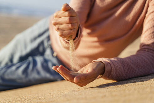 Sand falling out of woman's closed fist - DIGF17815