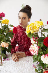 Beautiful young woman with colorful roses against white background - IYNF00129