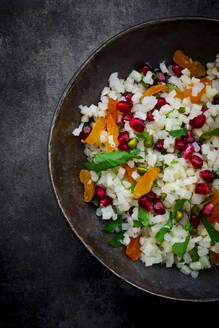 Studio shot of bowl of cauliflower salad with apricot, pomegranate seeds, pistachios, mint and parsley - LVF09229