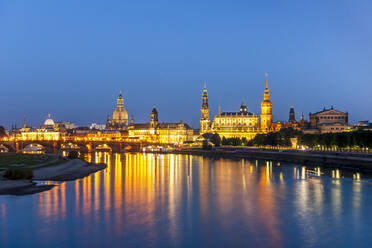 Germany, Saxony, Dresden, Long exposure of Elbe river at dusk with illuminated old town buildings in background - EGBF00839