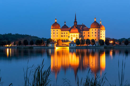 Deutschland, Sachsen, Moritzburg, Langzeitbelichtung von See und beleuchtetem Schloss Moritzburg in der Abenddämmerung - EGBF00863