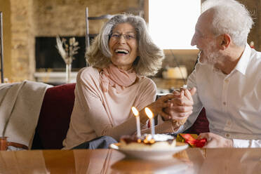 Glückliches älteres Paar mit Torte feiert Geburtstag im Boutique-Hotel - EIF03699